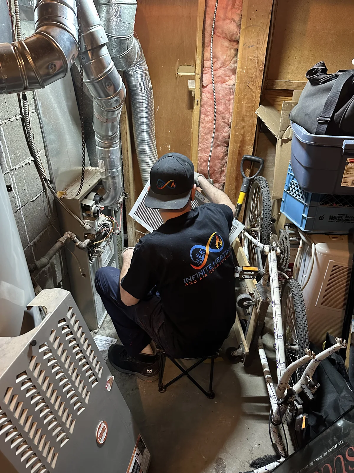 Infinite Heating technician working on residential furnace equipment